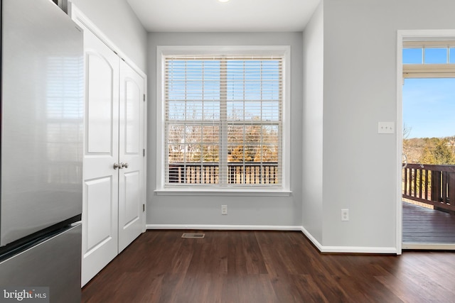 interior space featuring dark wood-style flooring, visible vents, and baseboards