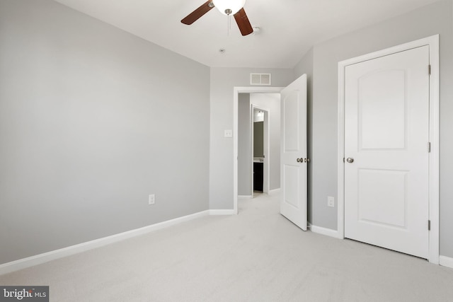 unfurnished bedroom featuring light colored carpet, visible vents, ceiling fan, and baseboards