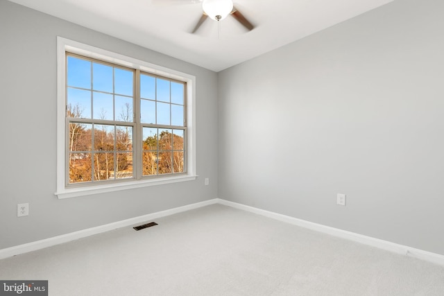 empty room featuring carpet floors, visible vents, ceiling fan, and baseboards