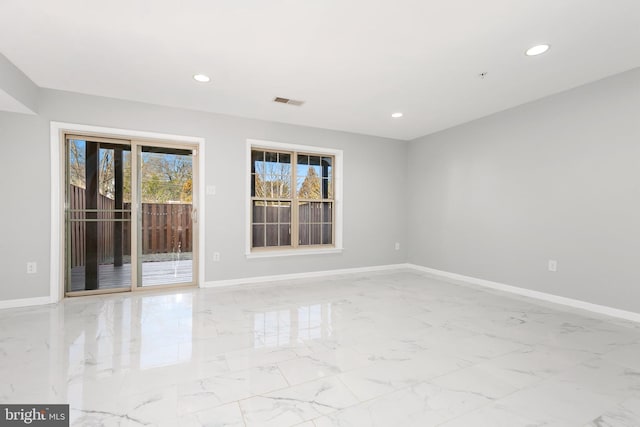 spare room featuring recessed lighting and baseboards