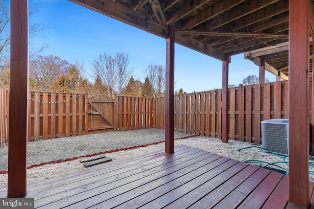 deck featuring cooling unit, a gate, and a fenced backyard