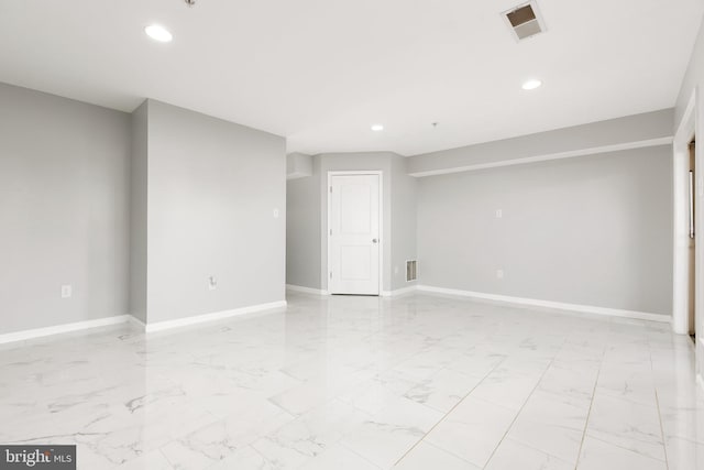 spare room with marble finish floor, baseboards, visible vents, and recessed lighting