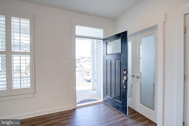 entryway with plenty of natural light, baseboards, and dark wood-style flooring