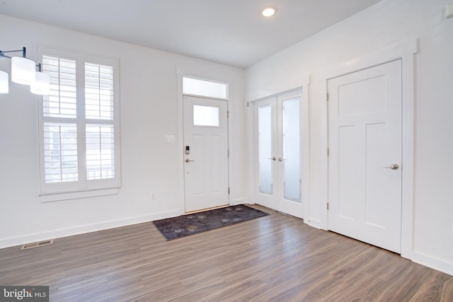 foyer entrance with dark wood-style floors, french doors, visible vents, and a healthy amount of sunlight