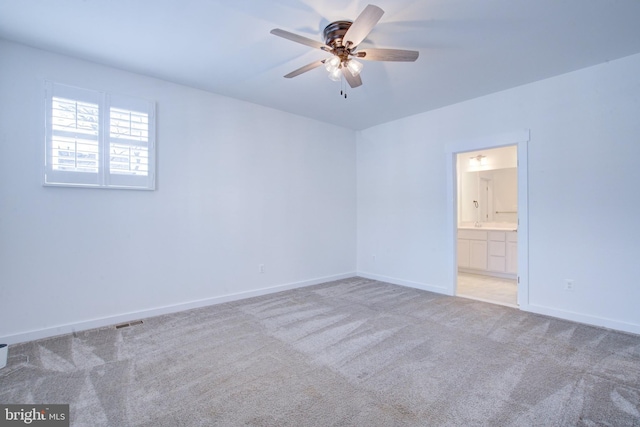 carpeted empty room featuring visible vents, ceiling fan, and baseboards