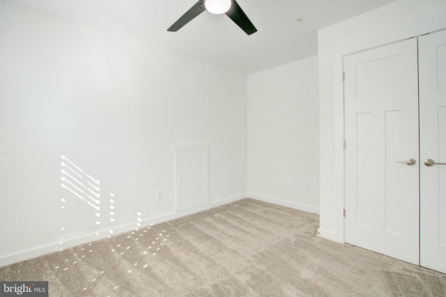 unfurnished bedroom featuring ceiling fan, baseboards, and light colored carpet