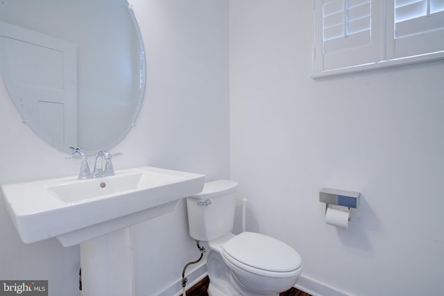 bathroom featuring toilet and baseboards