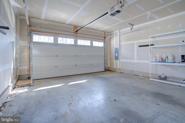 garage with a garage door opener and electric panel