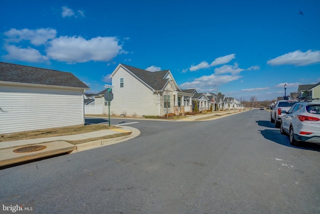 view of street featuring a residential view, curbs, and sidewalks