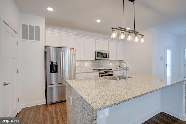 kitchen featuring light stone counters, a sink, visible vents, white cabinetry, and appliances with stainless steel finishes