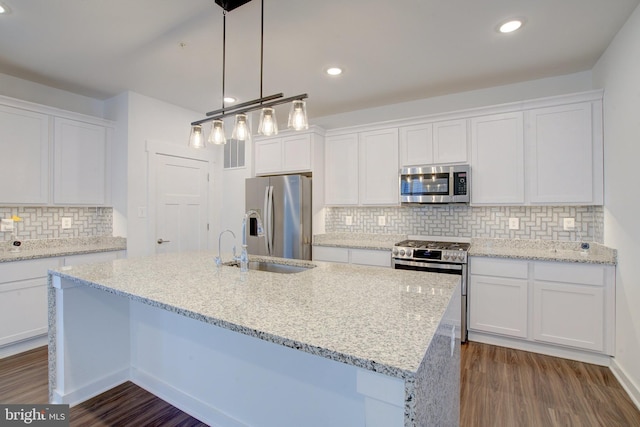 kitchen featuring white cabinets, a kitchen island with sink, and stainless steel appliances