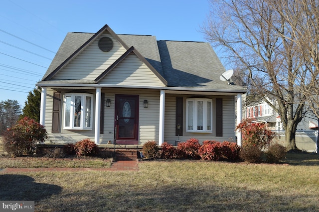 bungalow-style house with a shingled roof and a front yard