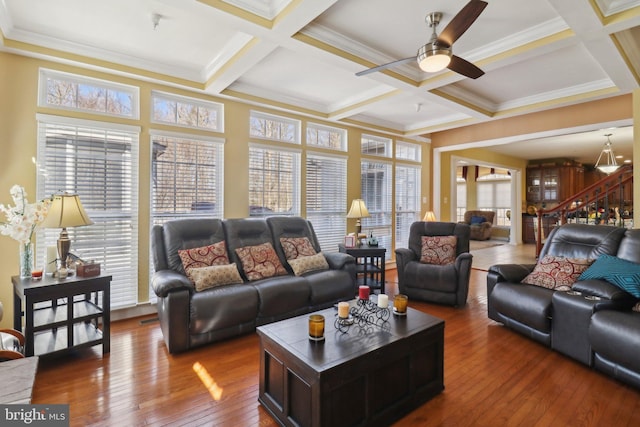 living room with hardwood / wood-style floors, coffered ceiling, plenty of natural light, and beamed ceiling