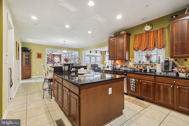 kitchen with sink, tasteful backsplash, a center island, and dishwasher