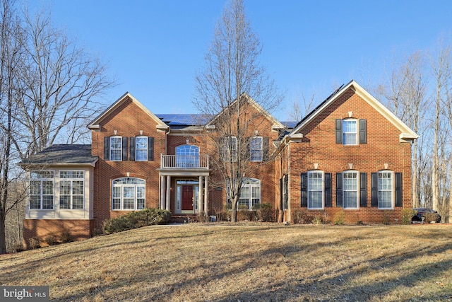 view of front of house featuring a front lawn and solar panels