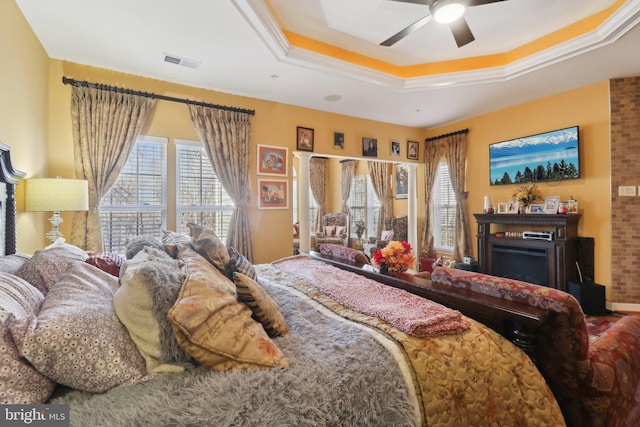 bedroom featuring a tray ceiling, ceiling fan, and crown molding