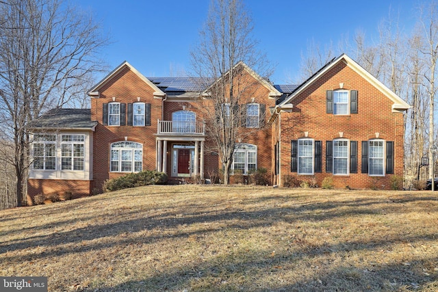 view of front facade with a front lawn and solar panels