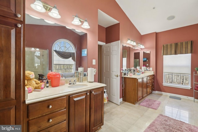 bathroom featuring tile patterned floors, vaulted ceiling, and vanity