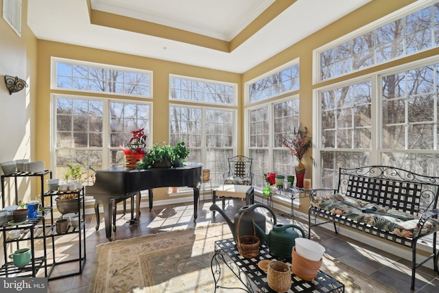 sunroom featuring a tray ceiling and a wealth of natural light