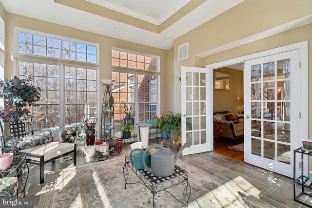 sunroom with a raised ceiling and french doors