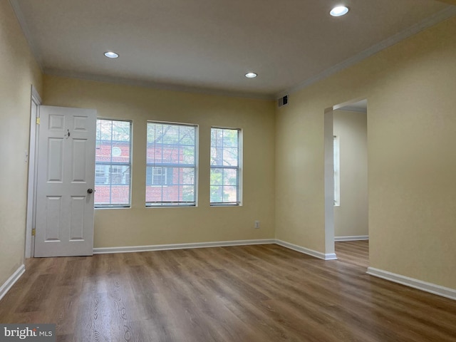 empty room featuring crown molding and hardwood / wood-style floors