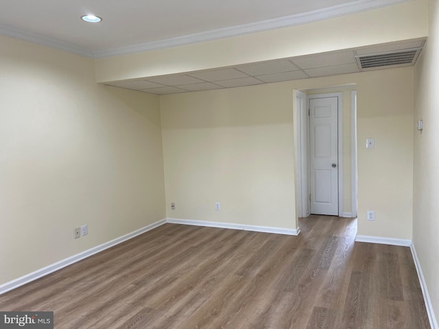 spare room featuring a drop ceiling, hardwood / wood-style floors, and crown molding