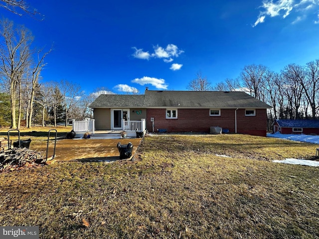 back of property with a yard and a deck