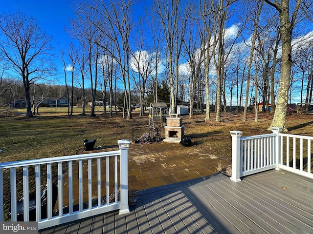 deck with a patio and an outdoor stone fireplace