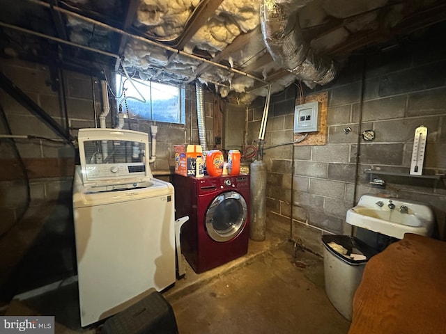 basement with sink, electric panel, and independent washer and dryer