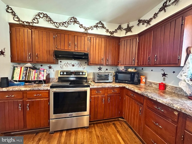 kitchen featuring light stone counters, hardwood / wood-style floors, and electric range