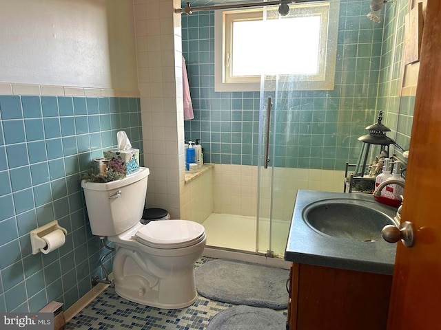 bathroom featuring tile walls, tile patterned flooring, vanity, toilet, and walk in shower