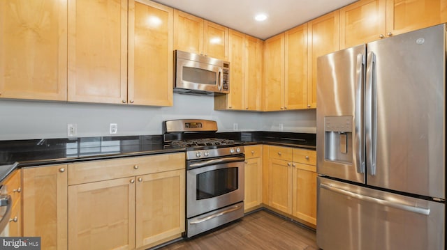 kitchen featuring appliances with stainless steel finishes, light brown cabinets, and dark hardwood / wood-style flooring