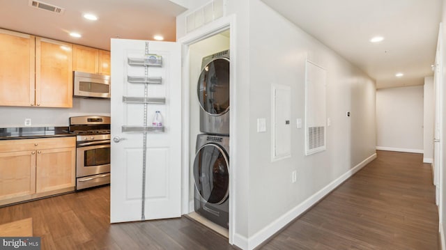 laundry area with dark hardwood / wood-style flooring and stacked washer and dryer