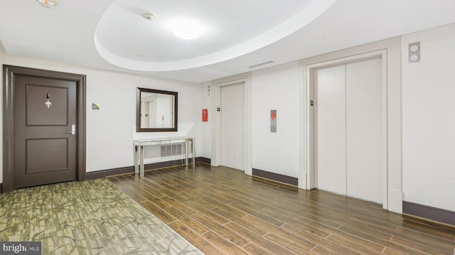 interior space featuring a tray ceiling and elevator