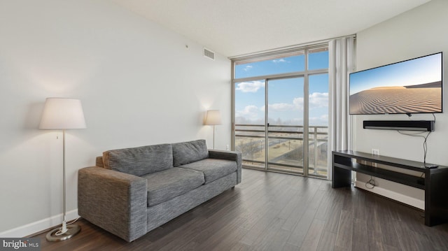 living room with dark wood-type flooring and floor to ceiling windows