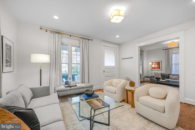 living area featuring baseboards, wood finished floors, and recessed lighting