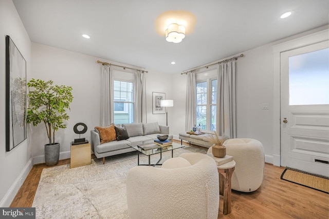 living area with recessed lighting, a healthy amount of sunlight, baseboards, and wood finished floors