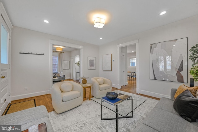 living area featuring baseboards, wood finished floors, and recessed lighting