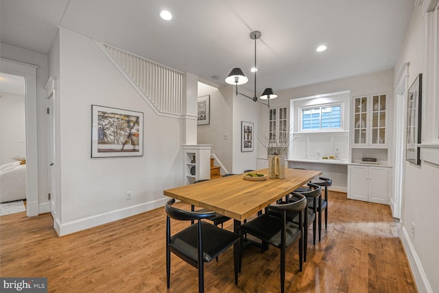 dining room featuring recessed lighting, light wood-style flooring, baseboards, and stairs