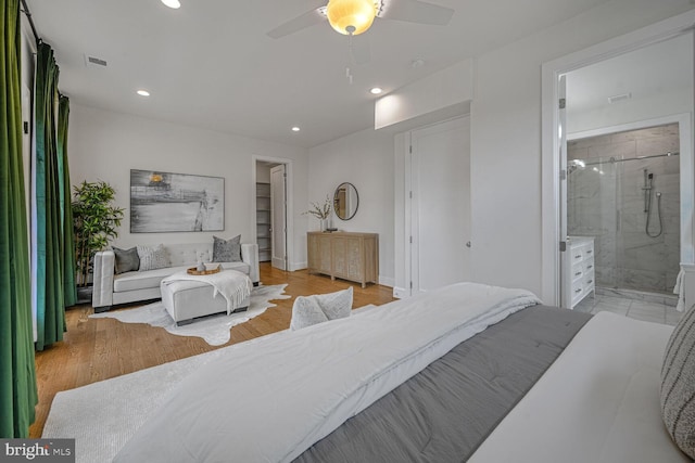 bedroom with light wood-type flooring, recessed lighting, baseboards, and ensuite bath