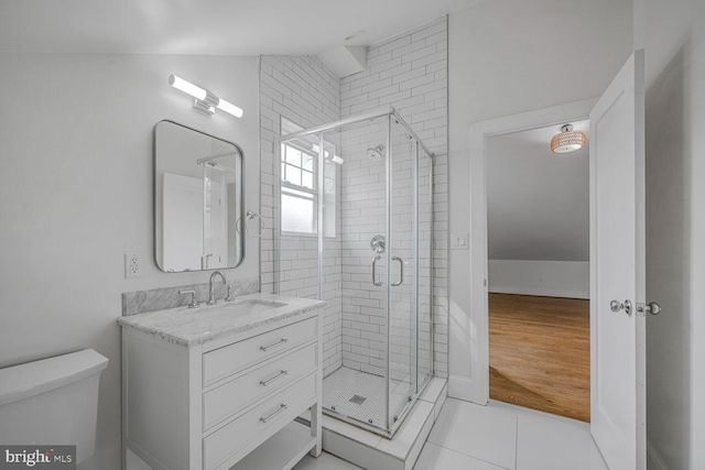 bathroom with toilet, a stall shower, tile patterned flooring, and vanity