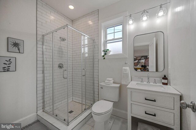 bathroom featuring baseboards, toilet, a shower stall, and vanity