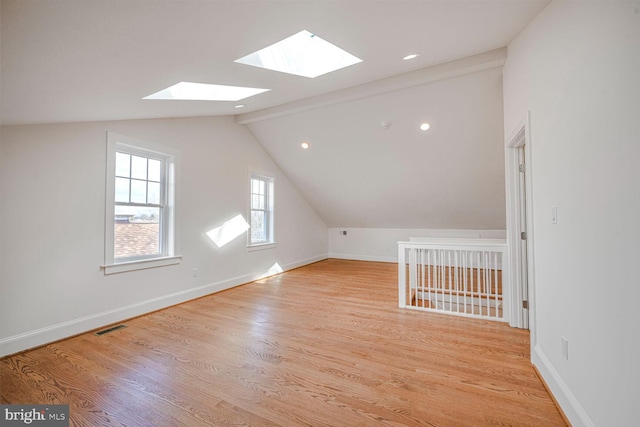 bonus room featuring lofted ceiling with beams, light wood-type flooring, visible vents, and baseboards