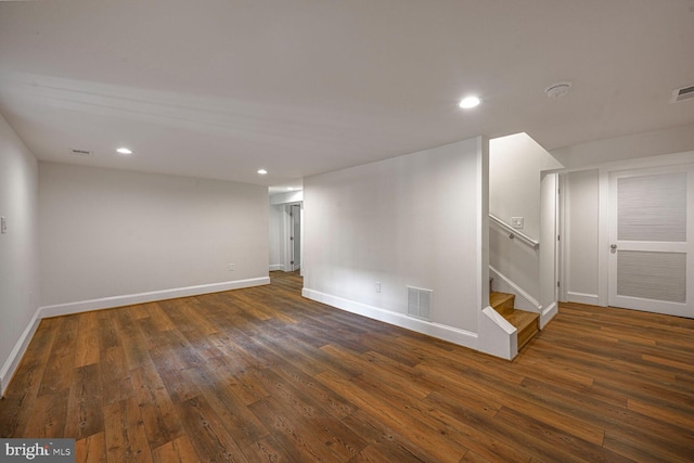 finished basement with baseboards, stairway, dark wood-style flooring, and recessed lighting