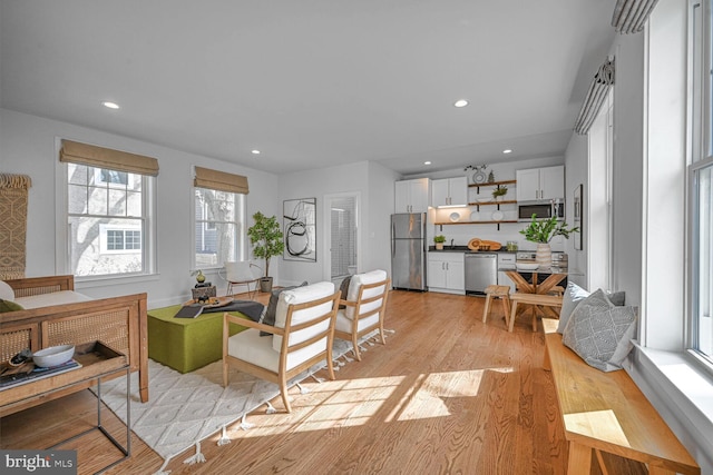 living area featuring light wood-type flooring and recessed lighting