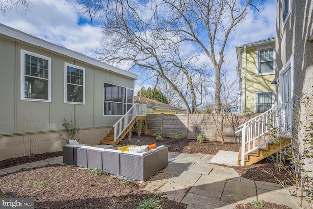 view of patio featuring an outdoor hangout area, stairway, and fence