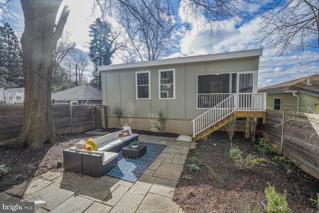 rear view of house featuring a fenced backyard, stairway, an outdoor living space, and a patio