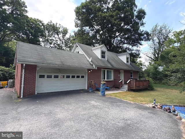 cape cod house with a garage, a front yard, and a deck