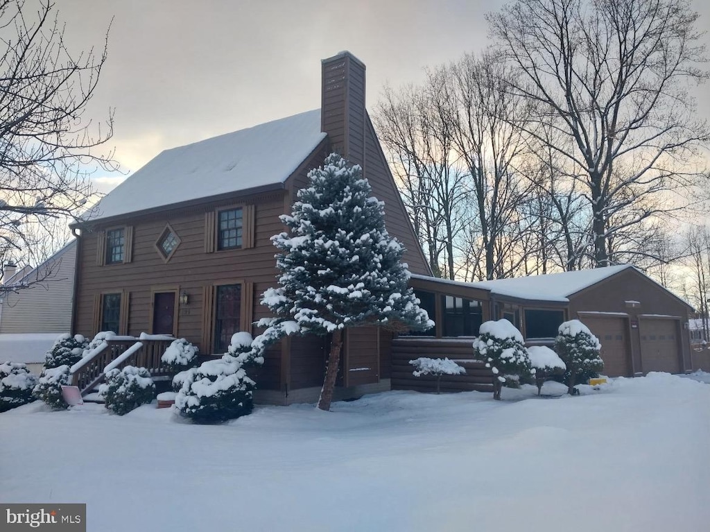 view of snow covered exterior featuring a garage