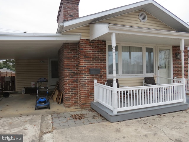 rear view of house featuring a porch and a carport